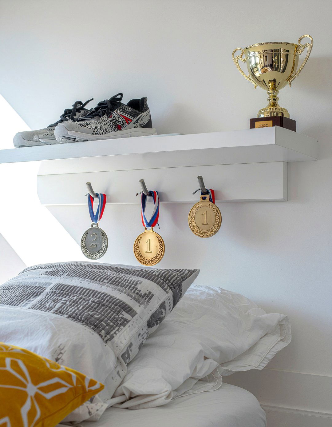 Floating shelf with hooks - 30 bedroom medal display ideas