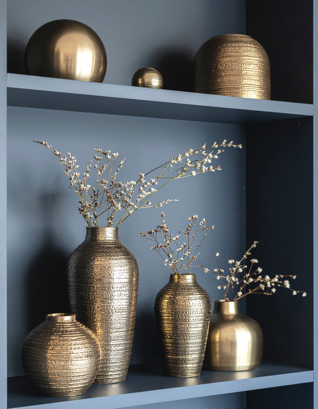 Gold decorative objects for navy shelves - 30 navy and gold living room ideas